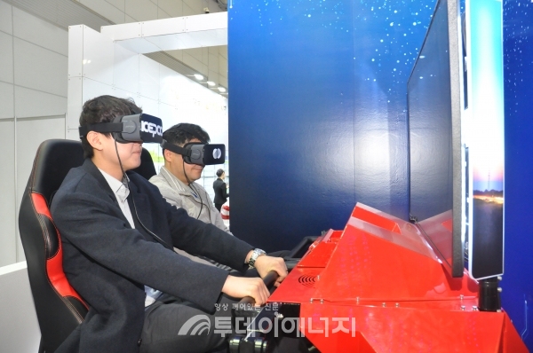 참관객들이 한국전력공사 부스에 설치된 전기차 VR시뮬레이션을 시연하고 있다.