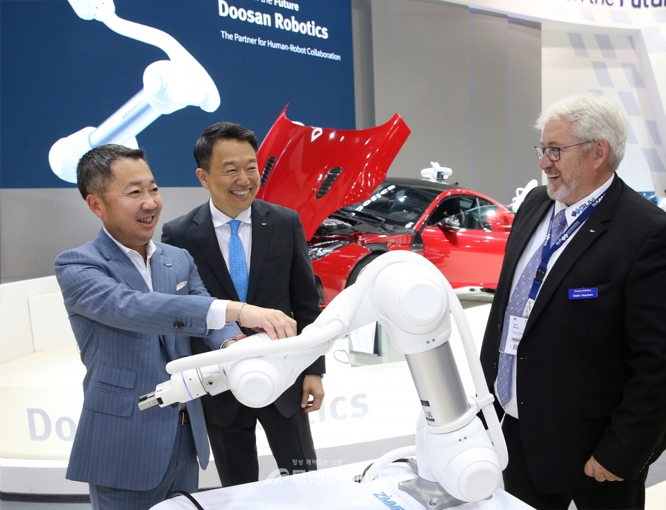 박정원 두산그룹 회장(좌)이 두산로보틱스 부스에서 독일 로봇시장 한 딜러업체 대표와 두산 협동로봇에 대해 이야기를 나누고 있다.