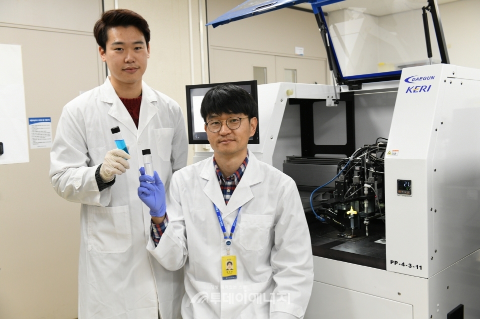 설승권 책임연구원과 이상현 박사과정생(좌)이 무전해도금법 기반 고전도성 구리 3D프린팅 잉크를 들고 있다.