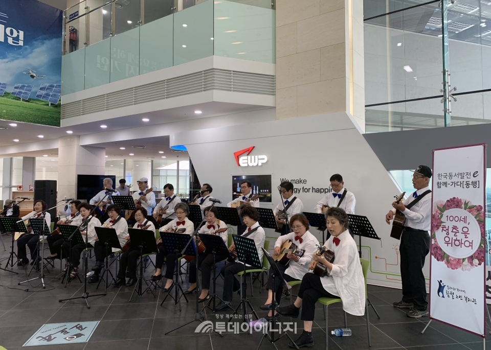 함월노인복지관의 기타 동아리원들이 한국동서발전 본사 로비에서 공연을 선보이고 있다.