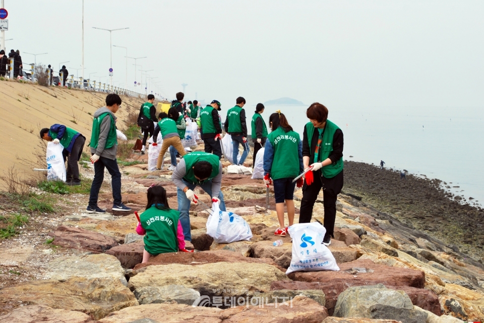삼천리 임직원가족과 시민봉사자들이 시화방조제에서 환경정화활동을 펼치고 있다.