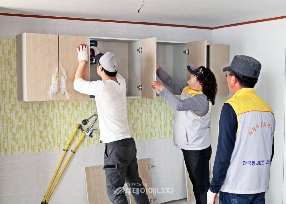 한국동서발전 직원들이 이웃 주민 가정을 방문하여 내부 수리를 돕고 있다.