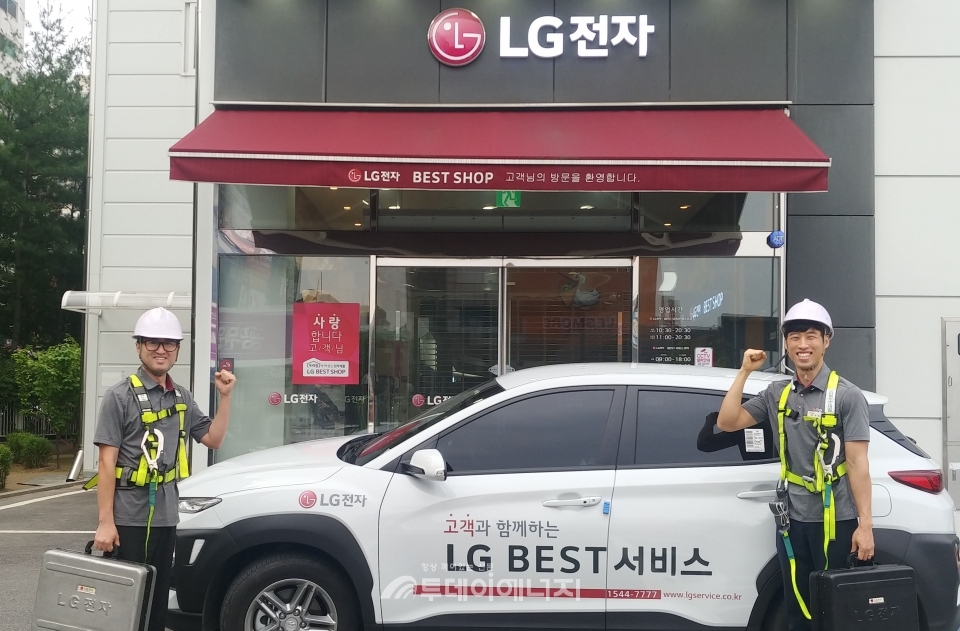 LG전자 서비스 엔지니어가 안전 보호구를 착용하고 신규 공급차량 앞에서 기념촬영을 하고 있다.