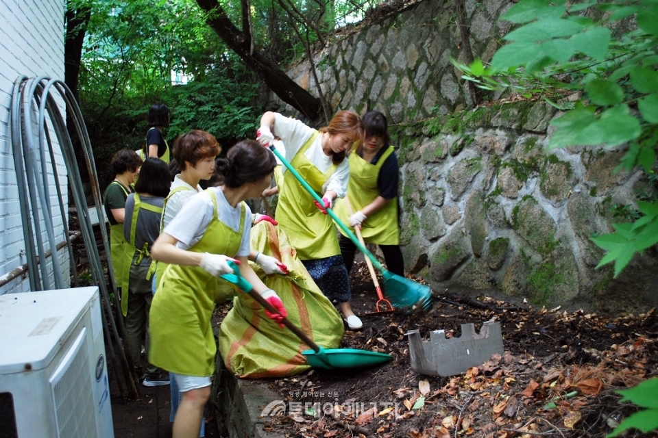 삼천리그룹 임원부인회와 여직원들이 안양의 집에서 야외 환경정화활동을 진행하고 있다.