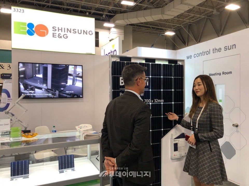 신성이엔지 관계자가 관람객에게 양면형 태양광모듈을 소개하고 있다.