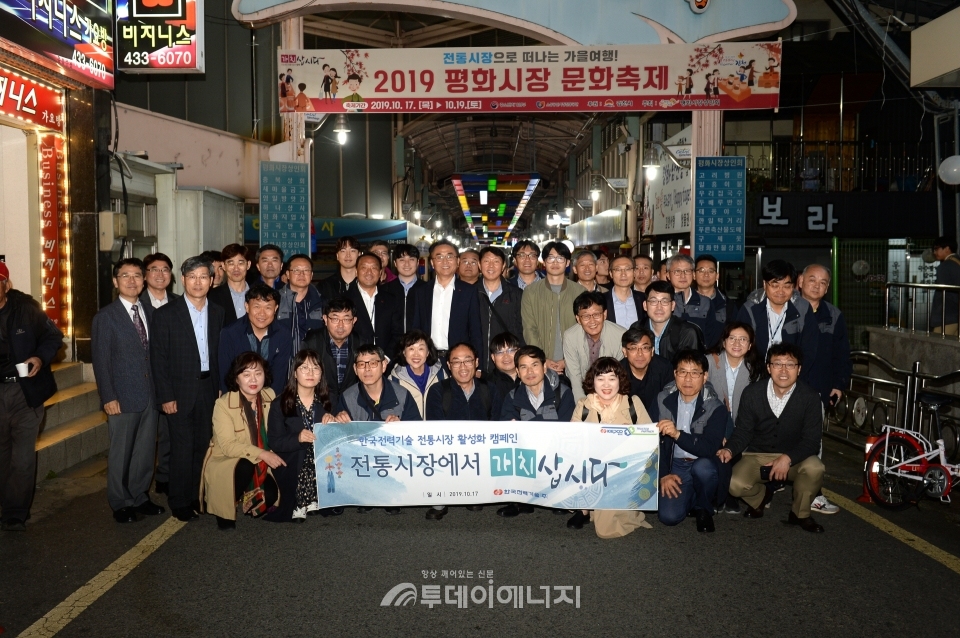 전통시장 활성화 캠페인에 참여한 한국전력기술 임직원들이 기념촬영을 하고 있다.