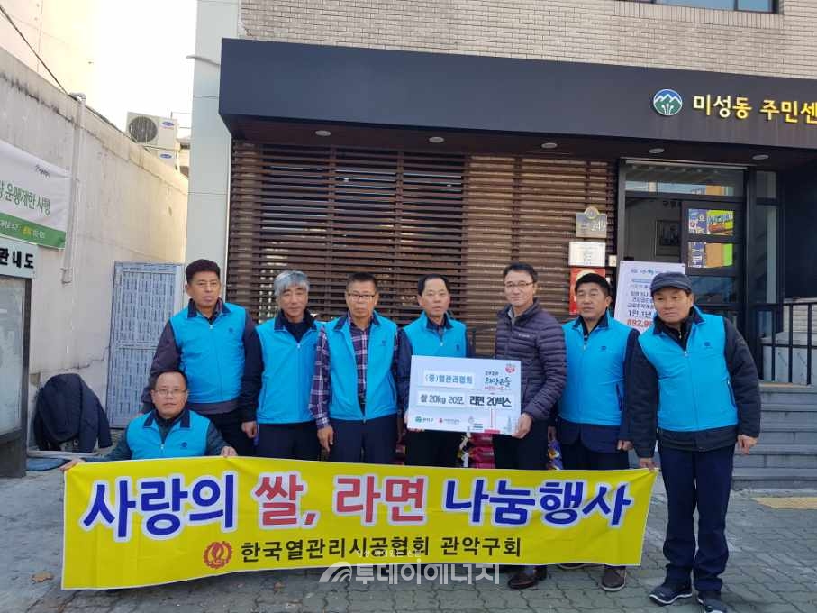 한국열관리시공협회 관악구회 회원들이 미성동 주님센터에 쌀과 라면을 전달하고 기념촬영을 하고 있다.