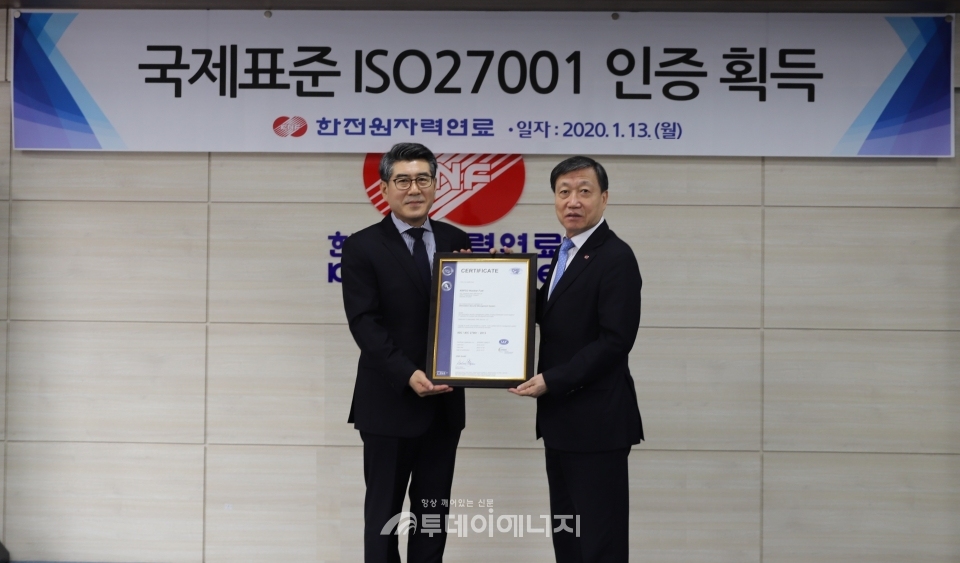 정상봉 한전원자력연료 사장(우)이 대전 본사에서 13일 이창호 DQS코리아 상무로부터 ISO27001 인증서를 수여받고 있다.