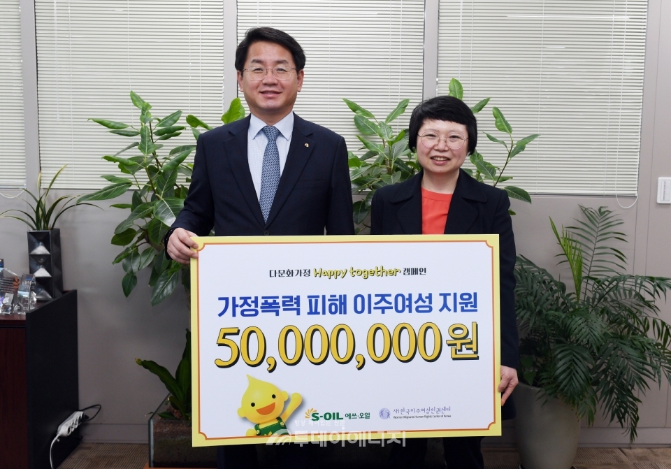 사회봉사단장인 선진영 S-OIL 전무(좌)가 서울 마포 소재  본사에서 허오영숙 한국이주여성인권센터 대표에게 가정폭력 피해 이주여성을 돕기 위한 5,000만원의 후원금을 전달 한 후 기념 촬영을 하고 있다.
