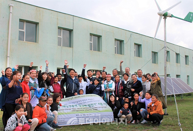 에너지나눔과평화 관계자들이 지난해 몽골 학교에 소형풍력발전기와 태양광발전기를 지원한 후 학생들과 기념촬영하고 있다.
