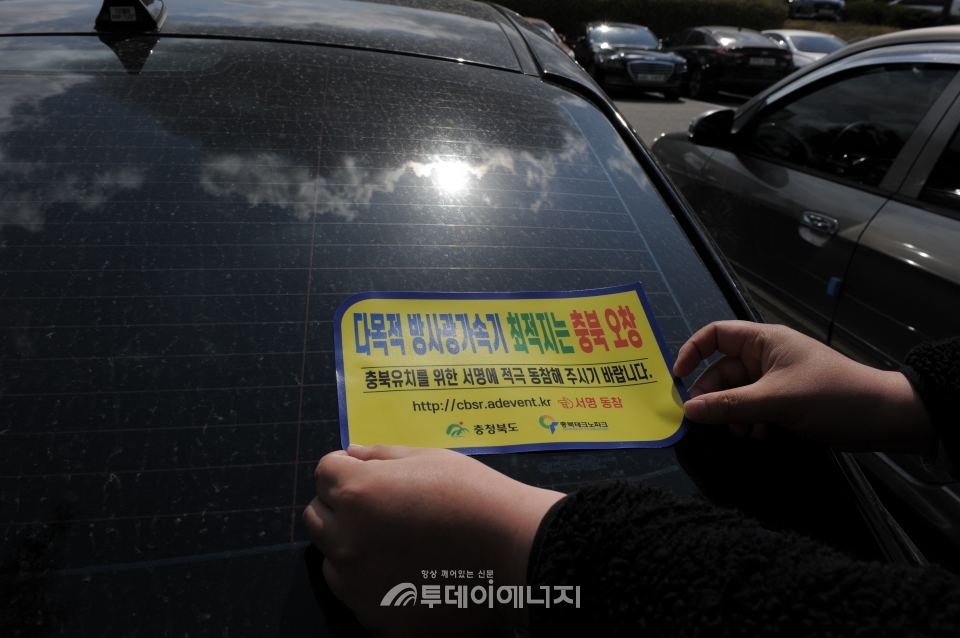 충북테크노파크 직원 차량에 충북 오창 다목적 방사광가속기 위치 스티커를 붙이고 있다.