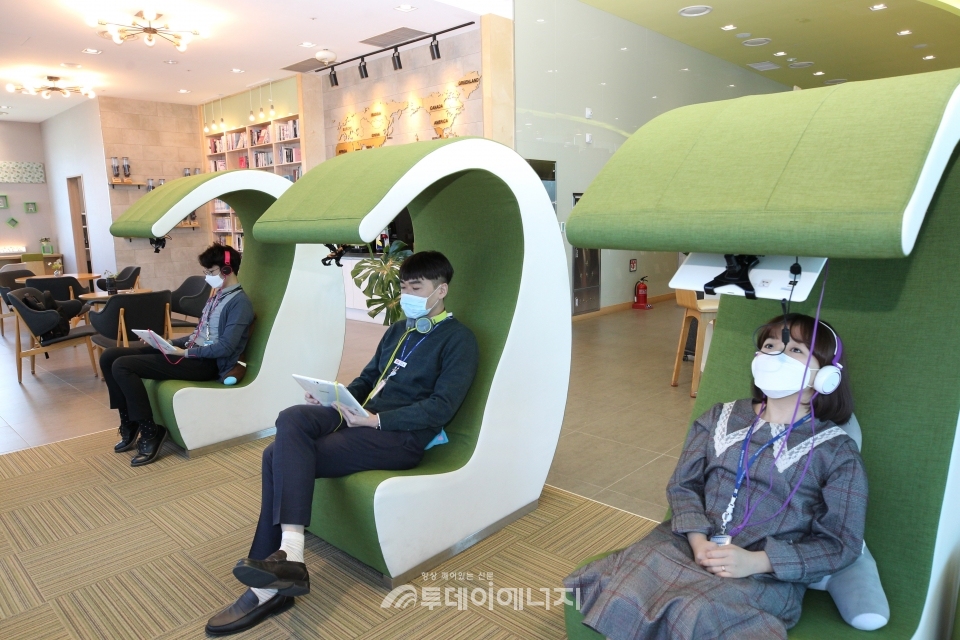 한국동서발전 직원들이 북카페에서 태블릿PC 등 전자기기를 활용해서 독서를 하고 있다.