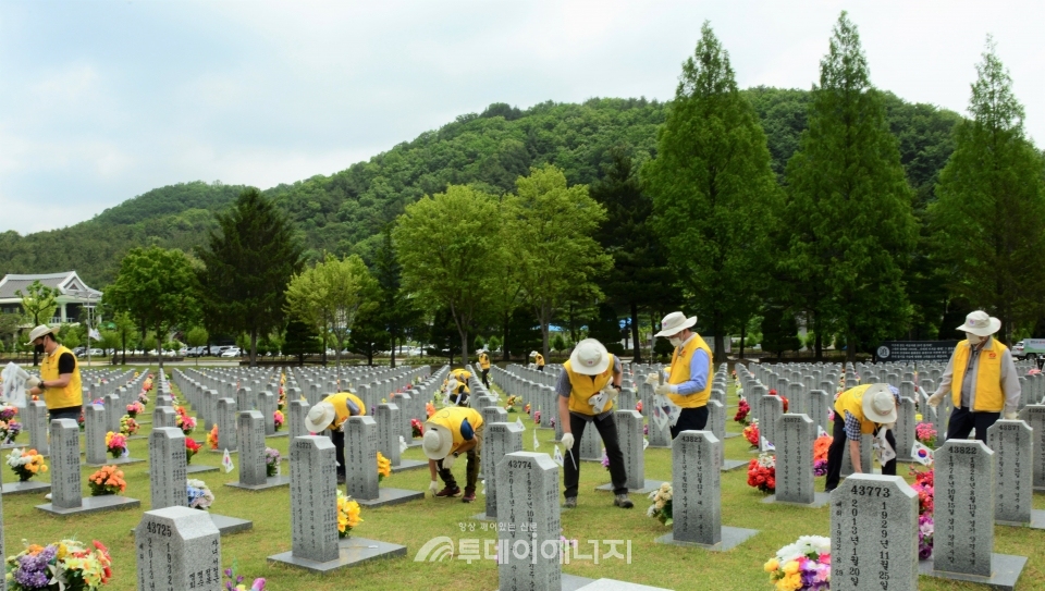 한전원자력연료 임직원들이 묘역관리 봉사활동을 펼치고 있다.