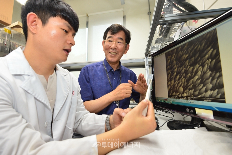 김지영 KIST 연구원(좌)과 이중기 KIST 책임연구원이 아연 금속의 표면처리 기술을 통해 육각뿔 피라미드 모양의 형상을 형성시킨 표면의 현미경 이미지를 확인하고 있다.