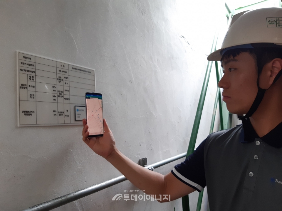 삼천리의 현장 점검 담당자가 정압기에 설치된 시설물 정보에 간단한 NFC 태깅 한번으로 시설물 위치 조회 및 점검결과를 전송하고 있다.