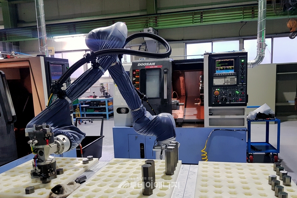 (주)두산이 협력사 스마트공장 구축을 위해 도입한 협동로봇이 생산현장에서 작업을 수행하고 있다.