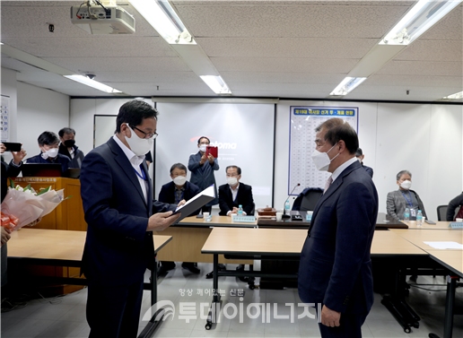 6파전의 경쟁에서 1위를  차지해 서울개인택시조합 이사장으로 당선된 차순선 씨(우)가 선거관리위원장으로부터 당선증을 받고 있다.