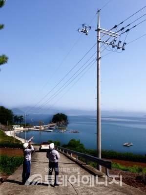한국전력 직원들이 드론을 활용하여 전력설비를 점검하고 있다.