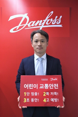 김성엽 댄포스 동북아 총괄대표가 어린이 교통안전 표어를 들고 기념촬영을 하고 있다.