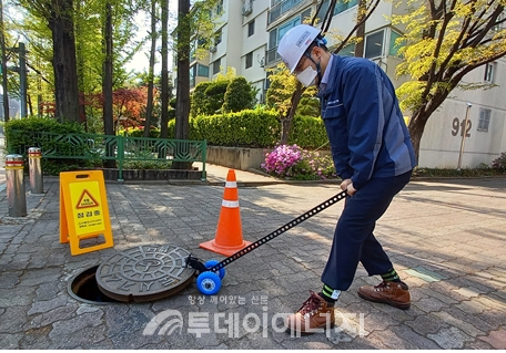 한 작업자가 서울도시가스가 개발한 오프너를 활용해 맨홀철개를 개방하고 있다.