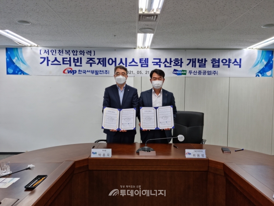 최용범 서부발전 기술안전본부장(우)과 박홍욱 두산중공업 부사장이 협약을 제결하고 기념촬영을 하고 있다.