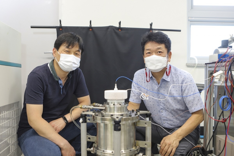 박성제 한국기계연구원 에너지기계연구본부 본부장(우)과 고준석 책임연구원이 개발한 스터링 냉동기와 기념촬영을 하고 있다.