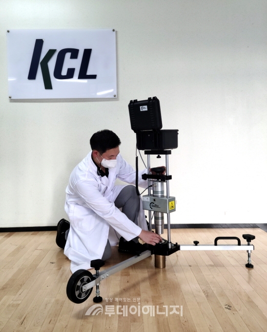 KCL의 관계자가 농구코트 바닥을 실험하고 있다.