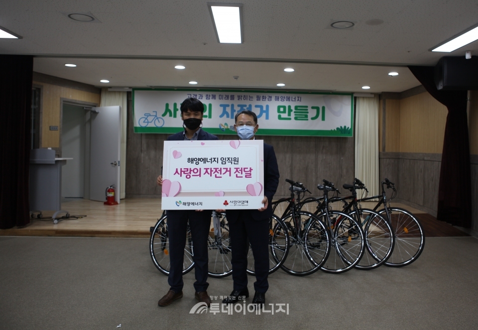 김형순 해양에너지 대표(우)가 자전거를 전달하고 기념 촬영하고 있다.
