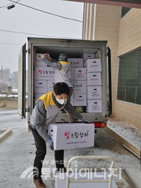 한국동서발전 당진발전본부 봉사단 직원이 석문면사무소에서 ‘빛드림 선물상자’를 운반하고 있다.