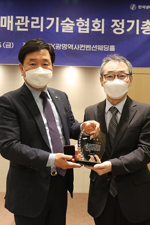 이용태 냉매관리기술협회 신임 회장이 김동호 전임 회장에게 감사패를 전달하고 기념촬영을 하고 있다.