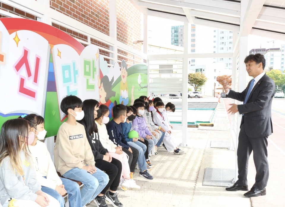 김영문 한국동서발전 사장(우)이 강남초등학교 학생들과 새로 설치된 태양광 쉼터 안에서 이야기를 나누고 있다.