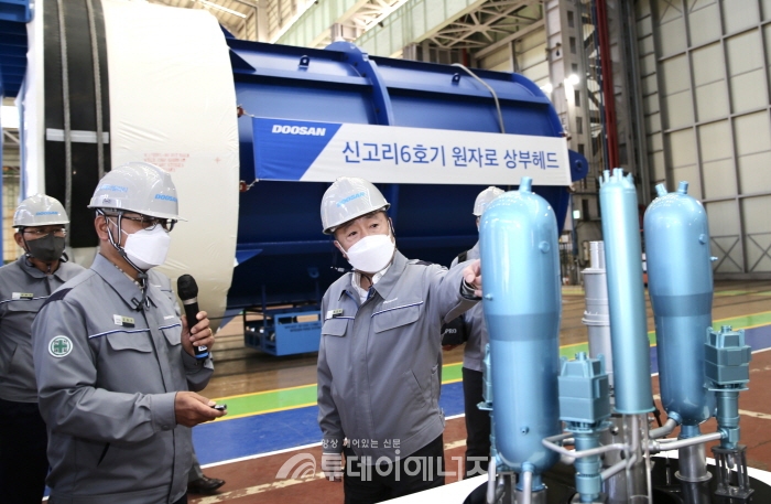 박정원 두산그룹 회장이 15일 경남 창원 두산에너빌리티 원자력 공장 내 원자로 헤드 앞에서 원전 모형을 보며 사업 현황을 점검하고 있다.