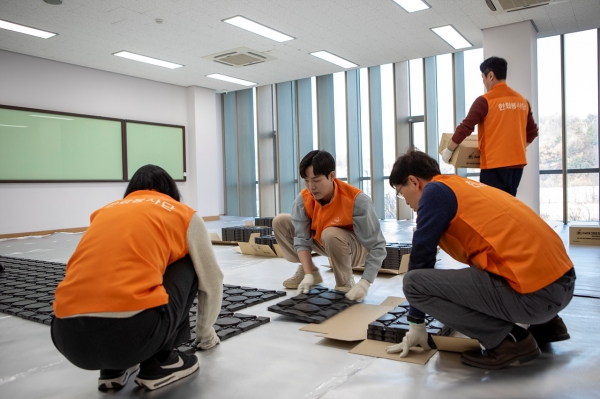 한화토탈에너지스 직원들이 서울시사회복지협의회와 함께 마포 자활센터를 방문해 바닥 난방용 온돌매트를 설치하고 있다/한화토탈에너지스 제공