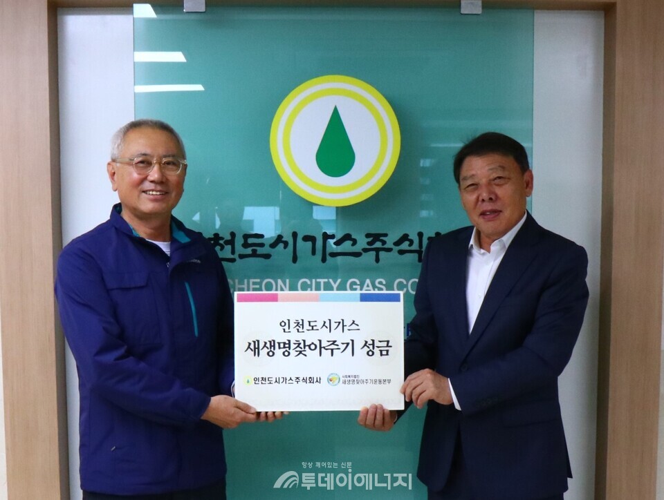 이상규 인천도시가스 이상규 상무이사(왼쪽)가 박준용 새생명찾아주기운동본부장에게 성금을 전달한 뒤 기념촬영을 하고 있다./안천도시가스 제공