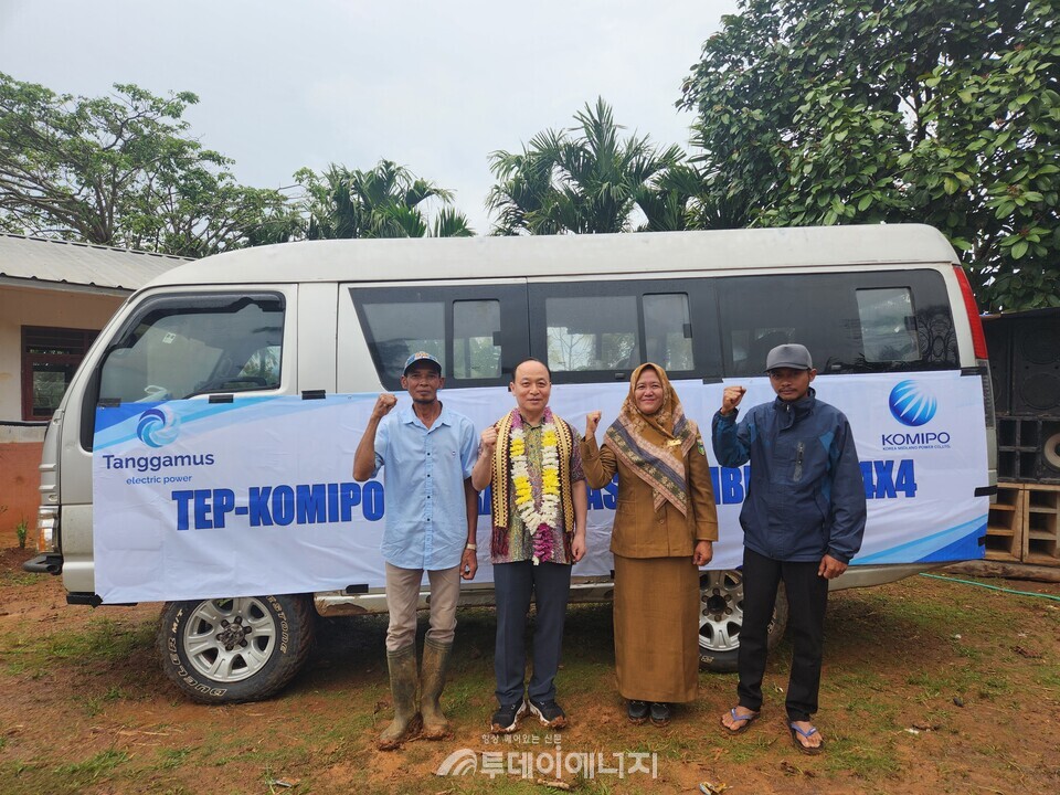 이영조 사장, 뮬리티아 교장, 마을 이장이 버스 기부행사 사진을 촬영하고 있다./한국중부발전 제공