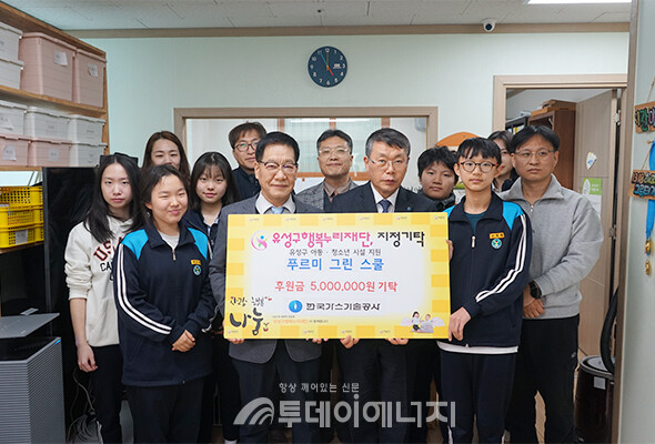  가스기술공사 진수남 사장직무대행(오른쪽)과 유성구행복누리재단 홍정환 상임이사(왼쪽)이 손피켓을 들고 아이들과 기념 촬영하고 있다. /가스기술공사 제공