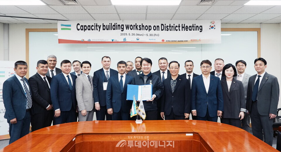 정용기 사장이 우즈벡정부의 감사장을 전달 받고 있다(왼쪽 6번째부터 우즈벡 열공급공사 술토노프 세르조드 부사장, 정용기 한난 사장)./ 한국지역난방공사 제공