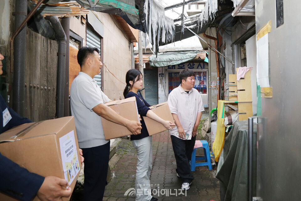 노용호 대한전기협회 상근부회장과 서포터즈 구성원들이 쪽방촌에 복지물품을 전달하고 있다. / 전기협 제공