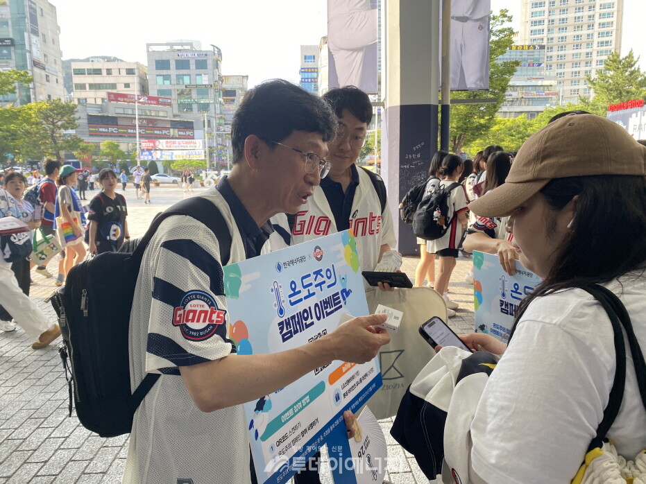 롯데자이언츠 사직구장에서 펼처진 '한국에너지공단-롯데자이언츠' 온도주의 공동 캠페인에서 공단 관계자들이 야구장을 찾은 관람객을 대상으로 온도주의 캠페인 이벤트 안내 및 굿즈를 배포하고 있다./ 한국에너지공단