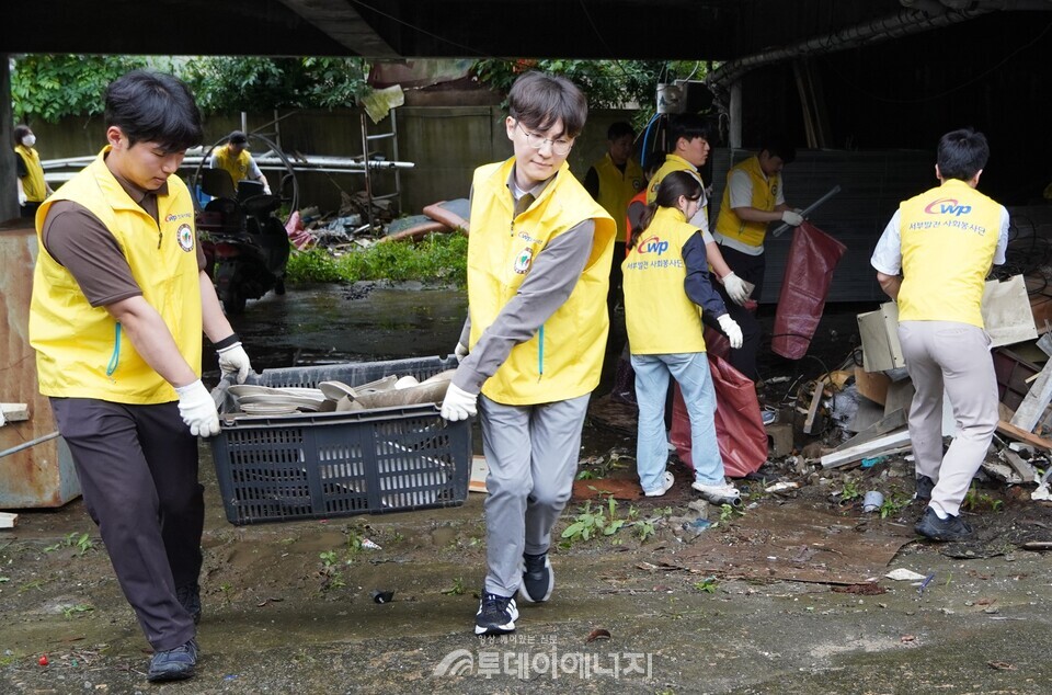 서부발전은 17일 밤사이 쏟아진 집중호우로 큰 침수 피해를 입은 충남 태안군 서부시장을 찾아 피해 복구 활동을 펼쳤다. 사진은 서부발전 직원들이 시장 인근에 흐트러진 생활 쓰레기와 잔해물을 정리하는 모습/한국서부발전 제공