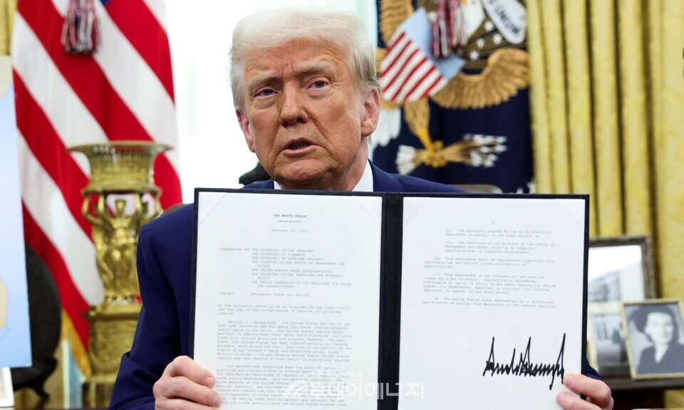 도널드 트럼프 미국 대통령이 이달 13일 워싱턴D.C 백악관 오벌오피스에서 각국에 ‘상호주의적 관세’를 부과하는 내용에 서명한 후 서명서를 들어보이고 있다./출처 VOA