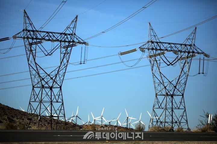 미국 캘리포니아주 팜스프링스의 송전탑과 그 뒤로 보이는 풍력 장치./ 로이터