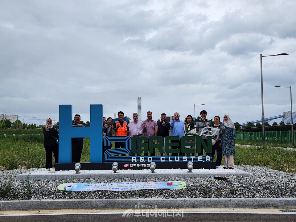 동서발전 실무자들과 요르단 에너지광물자원부 소속 실무자들이 그린수소 실증단지에서 기념사진을 찍는 모습/한국동서발전 제공