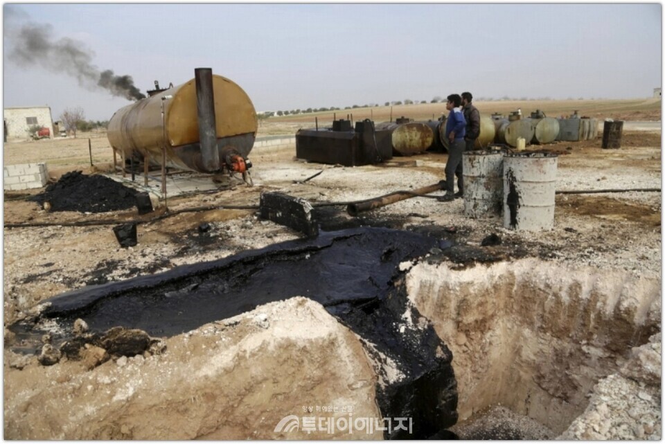2015년 12월, 시리아 이들립 주 마르크마린 마을의 임시 정유시설 현장에서 작업 중인 남성들.