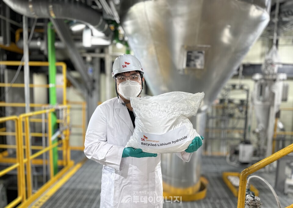 SK이노베이션 환경과학기술원 연구원이 폐배터리 수산화리튬 직접 회수 기술 상업화 실증 설비를 통해 회수한 재활용 수산화리튬을 소개하고 있다. / SK이노베이션 제공