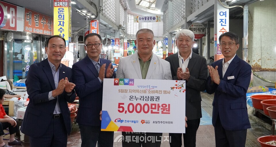 한국서부발전은 지난 23일 태안군 오일장을 찾은 지역민을 대상으로 지역특산품 소비 활성화 캠페인을 진행했다. 사진은 지난 22일 태안군 전통시장을 찾은 서규석 서부발전 미래사업부사장(왼쪽 첫 번째)이 이주영 태안군 부군수(오른쪽 첫 번째)와 조은상 태안군 오일장추진위원장(오른쪽 세 번째)에게 온누리 상품권 5000만 원을 전달하는 모습 / 한국서부발전 제공